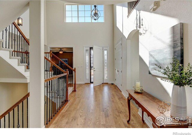 entryway featuring a high ceiling, a notable chandelier, and light hardwood / wood-style flooring