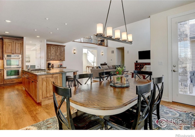 dining space with a notable chandelier and light hardwood / wood-style floors