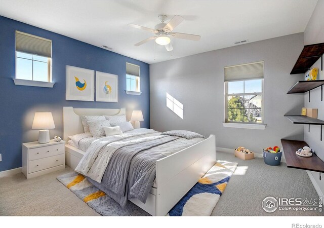 bedroom with multiple windows, light colored carpet, and ceiling fan