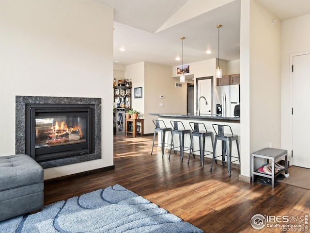 living room with vaulted ceiling, sink, and dark hardwood / wood-style flooring