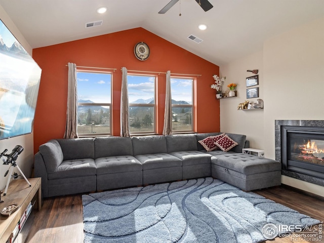 living room featuring dark wood-type flooring, ceiling fan, and vaulted ceiling