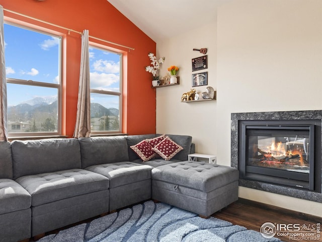 living room featuring vaulted ceiling, a mountain view, dark wood-type flooring, and a high end fireplace