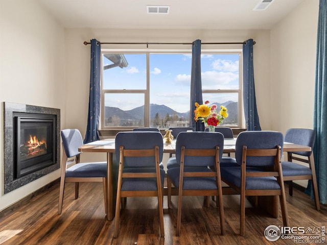 dining area with dark hardwood / wood-style flooring and a mountain view