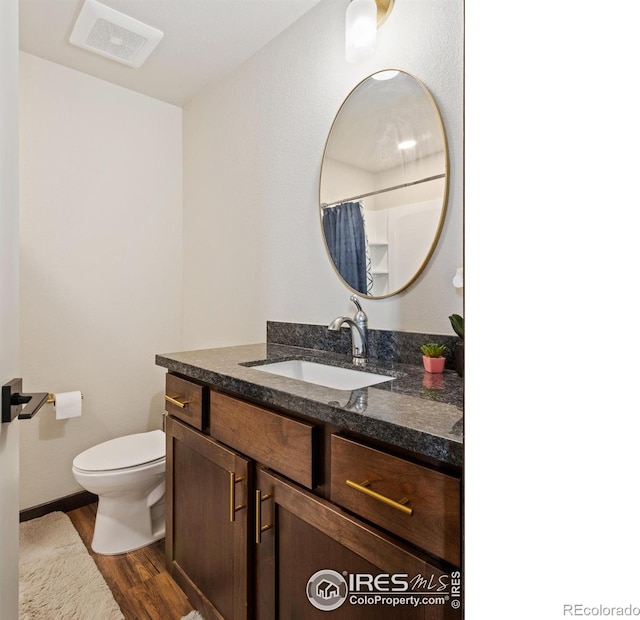 bathroom with wood-type flooring, toilet, a shower with shower curtain, and vanity