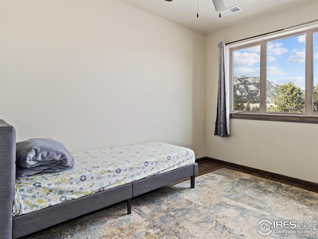 bedroom with a mountain view and hardwood / wood-style floors