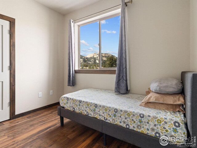 bedroom with dark wood-type flooring and a mountain view