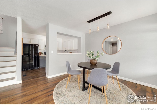 dining space with dark wood-style floors, baseboards, and stairway
