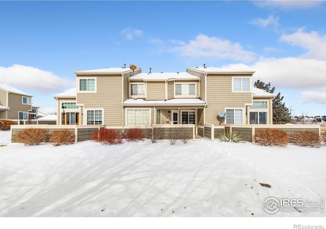 snow covered property with a fenced front yard