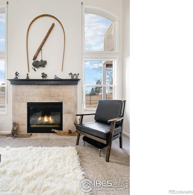 sitting room with light colored carpet and a tile fireplace