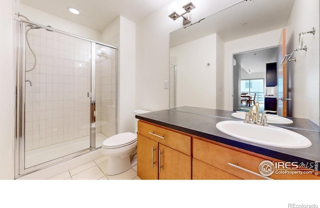 bathroom featuring an enclosed shower, vanity, tile patterned flooring, and toilet