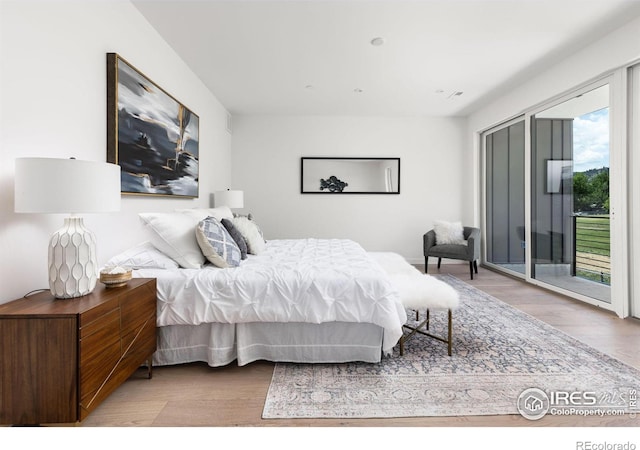 bedroom with access to exterior and light hardwood / wood-style flooring