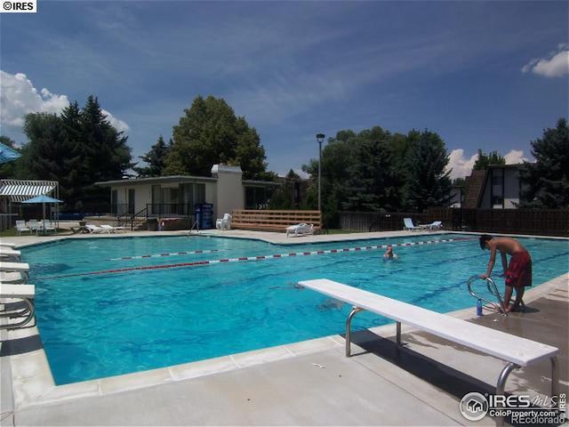 view of pool featuring a diving board and a patio