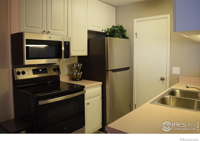 kitchen with sink, white cabinets, and appliances with stainless steel finishes