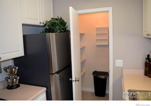 kitchen featuring white cabinetry and stainless steel refrigerator