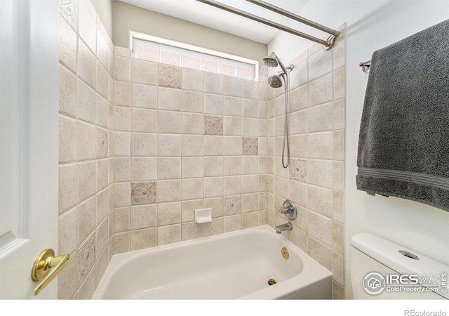 bathroom with tiled shower / bath combo and toilet