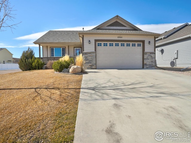 view of front of home featuring stone siding, an attached garage, and concrete driveway