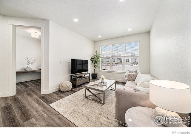 living room with dark hardwood / wood-style floors and a textured ceiling