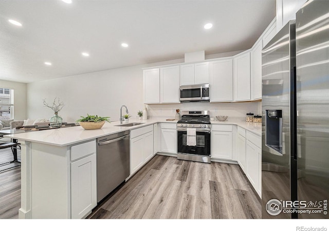 kitchen featuring stainless steel appliances, sink, and white cabinets