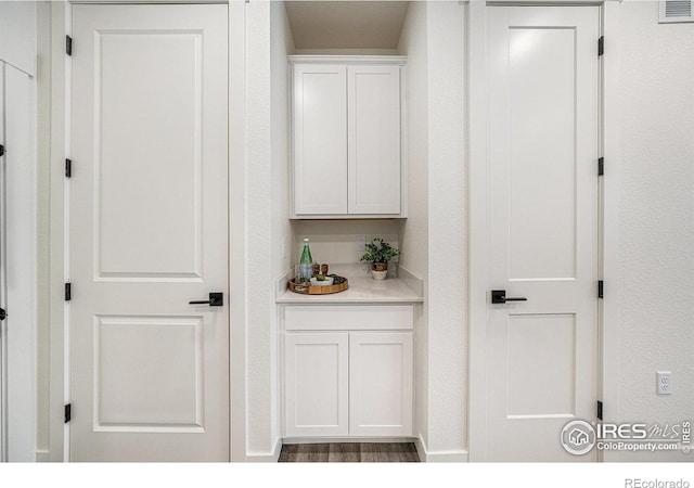 interior space with white cabinetry and hardwood / wood-style flooring