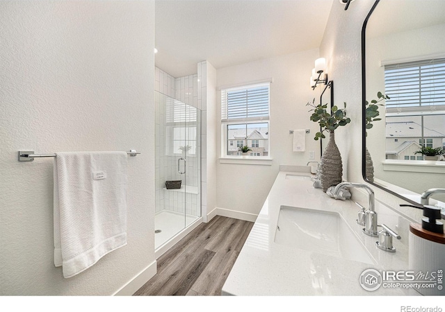 bathroom featuring hardwood / wood-style flooring, vanity, and walk in shower