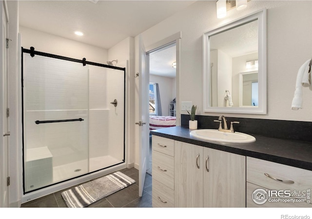 bathroom with vanity, an enclosed shower, and tile patterned flooring