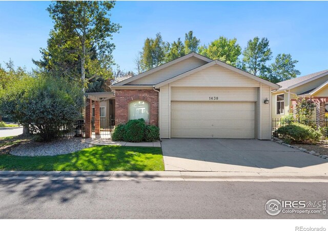 ranch-style home with an attached garage, driveway, brick siding, and fence