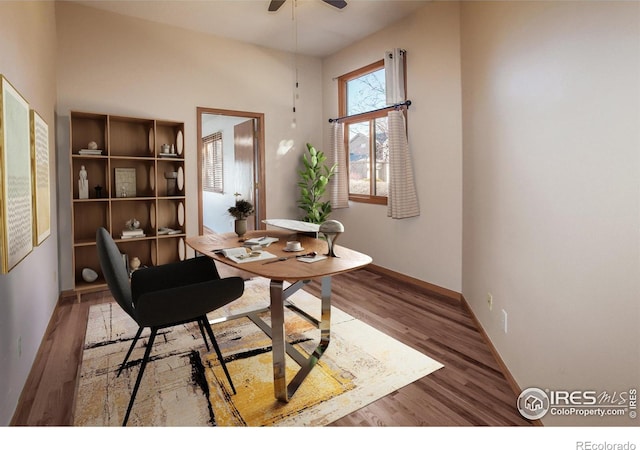 office area featuring wood finished floors, baseboards, and ceiling fan
