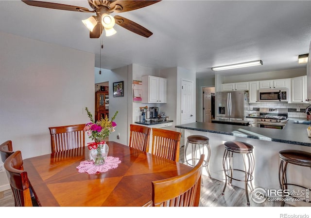 dining space featuring ceiling fan and light wood-style flooring