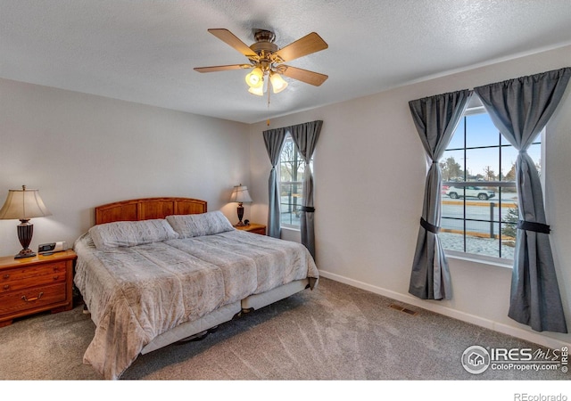 bedroom featuring baseboards, visible vents, a ceiling fan, a textured ceiling, and carpet flooring