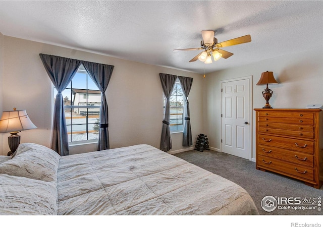 bedroom featuring a textured ceiling, carpet floors, ceiling fan, and baseboards