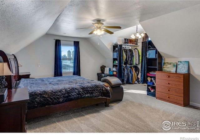 bedroom featuring a ceiling fan, carpet, vaulted ceiling, a textured ceiling, and a closet