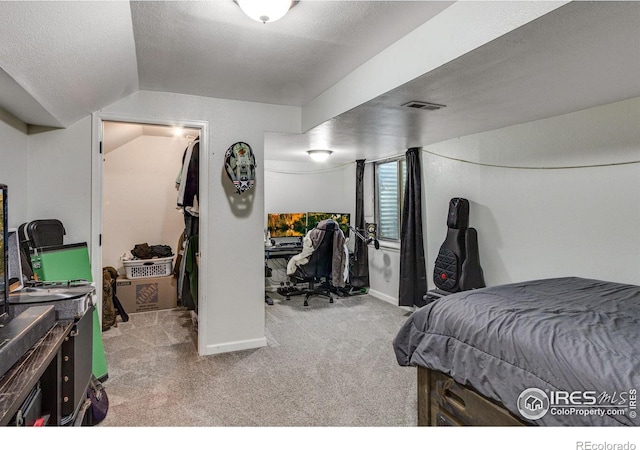 bedroom with lofted ceiling, a textured ceiling, visible vents, and carpet flooring