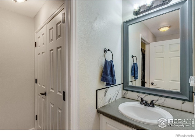 bathroom with a textured wall and vanity