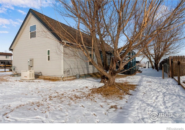 view of snow covered exterior with fence