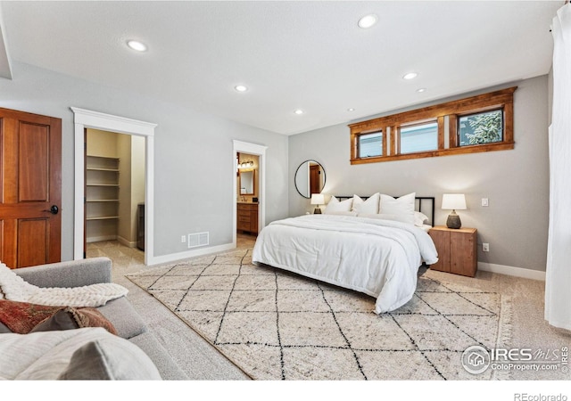 carpeted bedroom featuring a spacious closet and connected bathroom