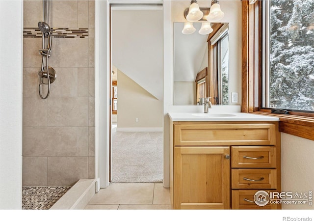 bathroom featuring tiled shower, vanity, and tile patterned flooring