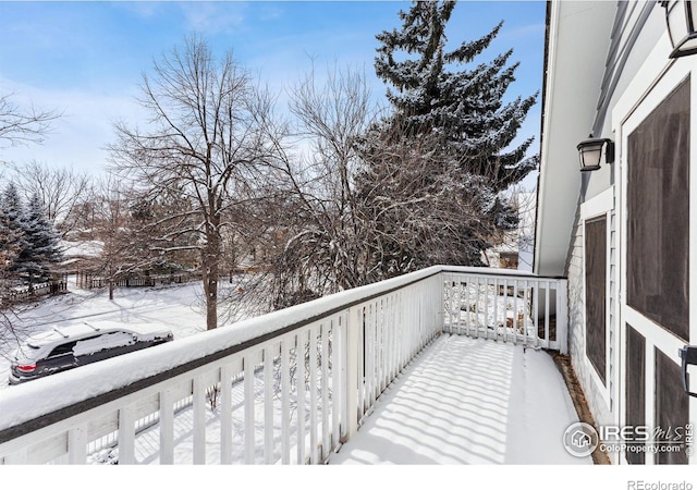 view of snow covered back of property