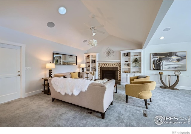 living room featuring a tiled fireplace, lofted ceiling, carpet flooring, and ceiling fan