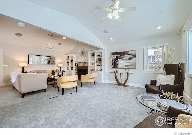 carpeted living room with a tiled fireplace, vaulted ceiling, and ceiling fan