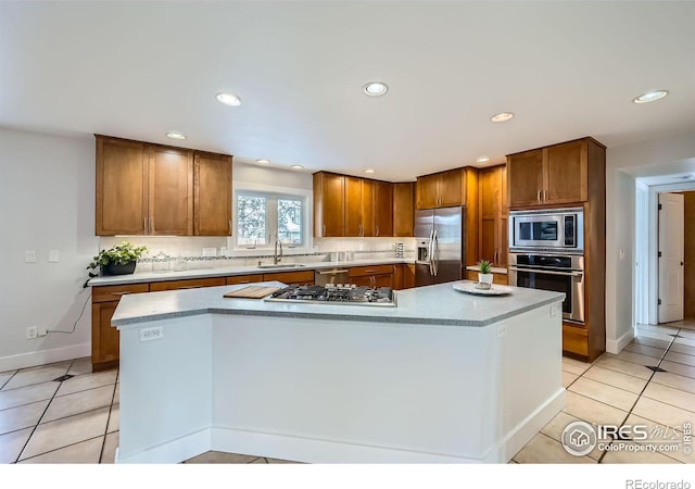 kitchen featuring stainless steel appliances, sink, a kitchen island, and backsplash