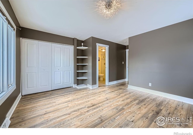 unfurnished bedroom with connected bathroom, light hardwood / wood-style floors, and a closet