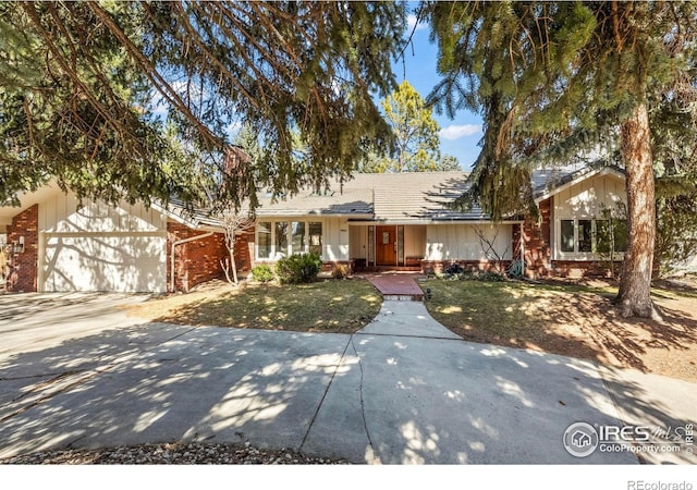 ranch-style house featuring brick siding, driveway, a front yard, and a garage