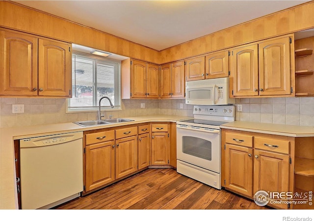 kitchen featuring dark wood-type flooring, white appliances, sink, and backsplash