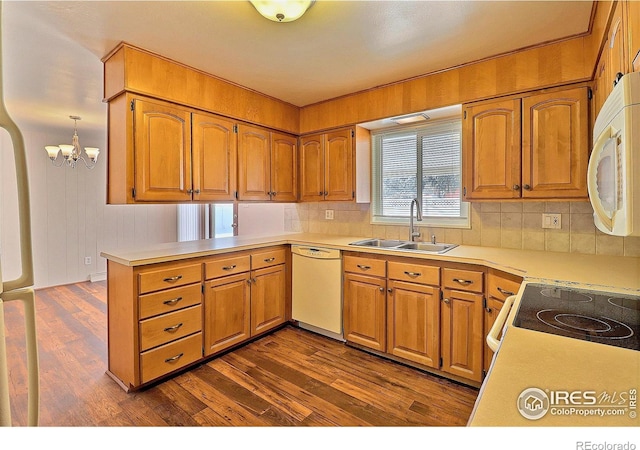 kitchen featuring dark hardwood / wood-style floors, sink, pendant lighting, and white appliances