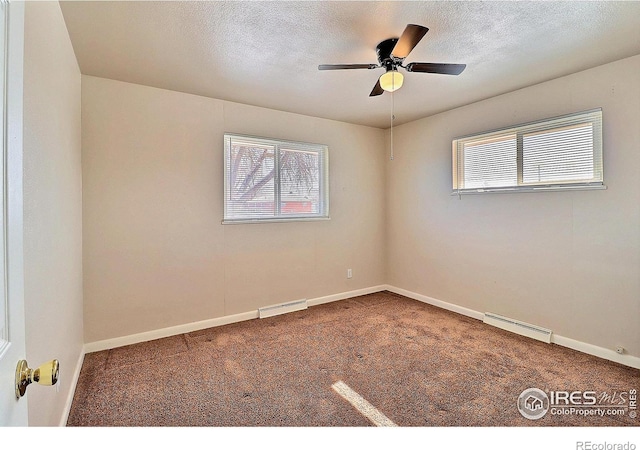 carpeted empty room with ceiling fan and a textured ceiling