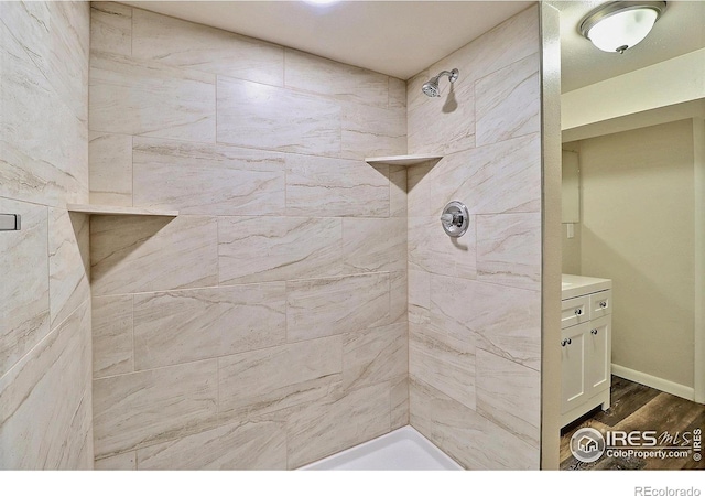 bathroom featuring hardwood / wood-style flooring and a tile shower