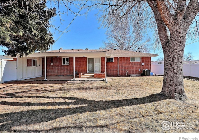 rear view of house with a yard, cooling unit, and a patio area