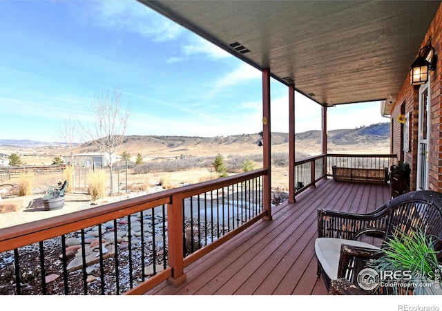 wooden terrace featuring a mountain view and a rural view