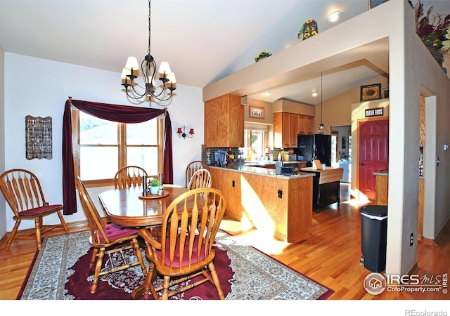 2707 Sedona Hills Dr, Loveland, CO 80537 - dining area featuring vaulted ceiling, a chandelier, and light hardwood / wood-style flooring