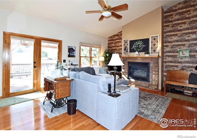 2707 Sedona Hills Dr, Loveland, CO 80537 - living room featuring ceiling fan, hardwood / wood-style floors, high vaulted ceiling, a brick fireplace, and french doors
